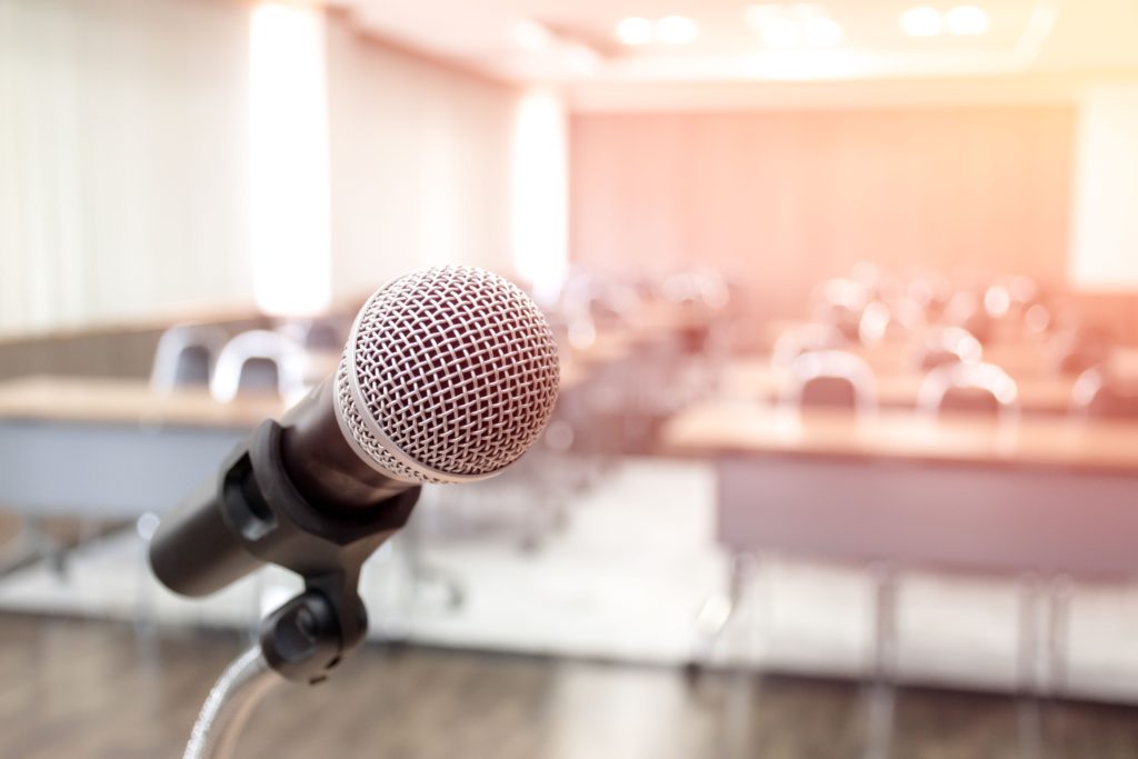 Microphone on abstract blurred of speech in seminar room